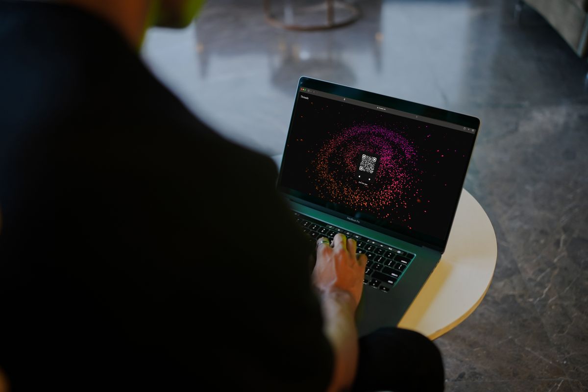 Seseorang menggunakan laptop yang layarnya menampilkan kode QR, menggambarkan cara membuat kode QR gratis di laptop tanpa aplikasi tambahan