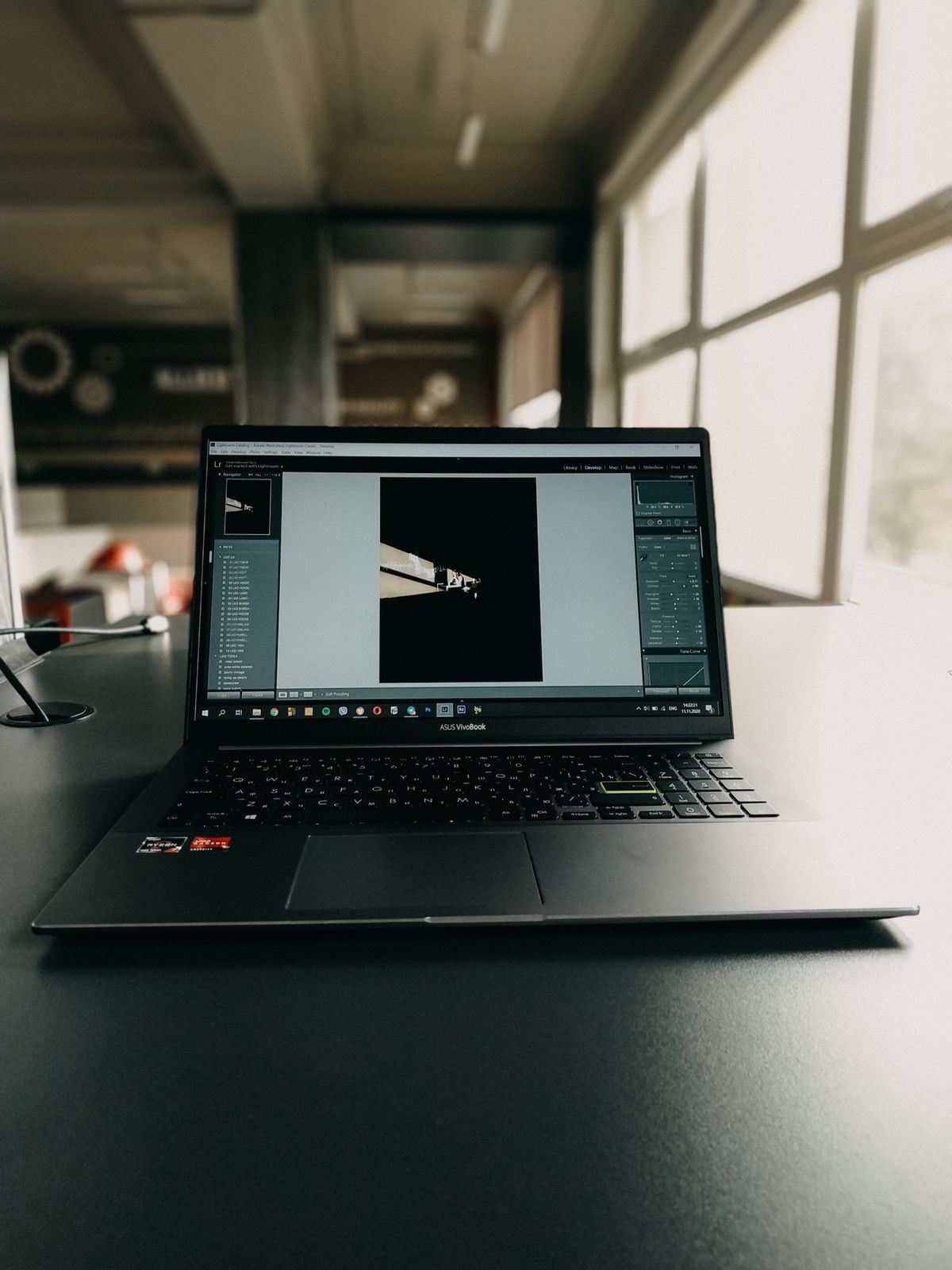 Laptop di atas meja kantor yang menampilkan jendela aplikasi edit foto dengan panel alat dan foto, menggambarkan tampilan editor foto di browser